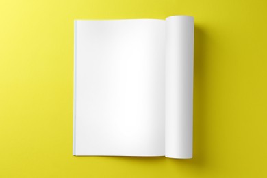 Photo of Open magazine on yellow background, top view. Mockup for design