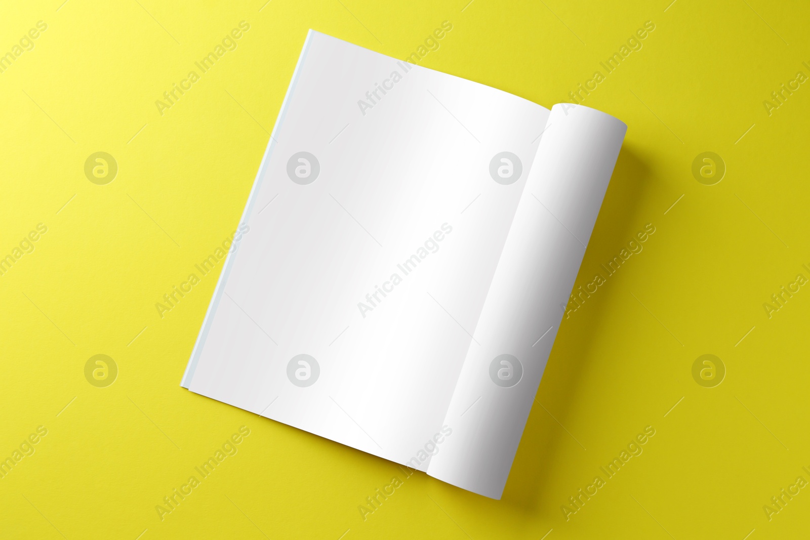 Photo of Open magazine on yellow background, top view. Mockup for design