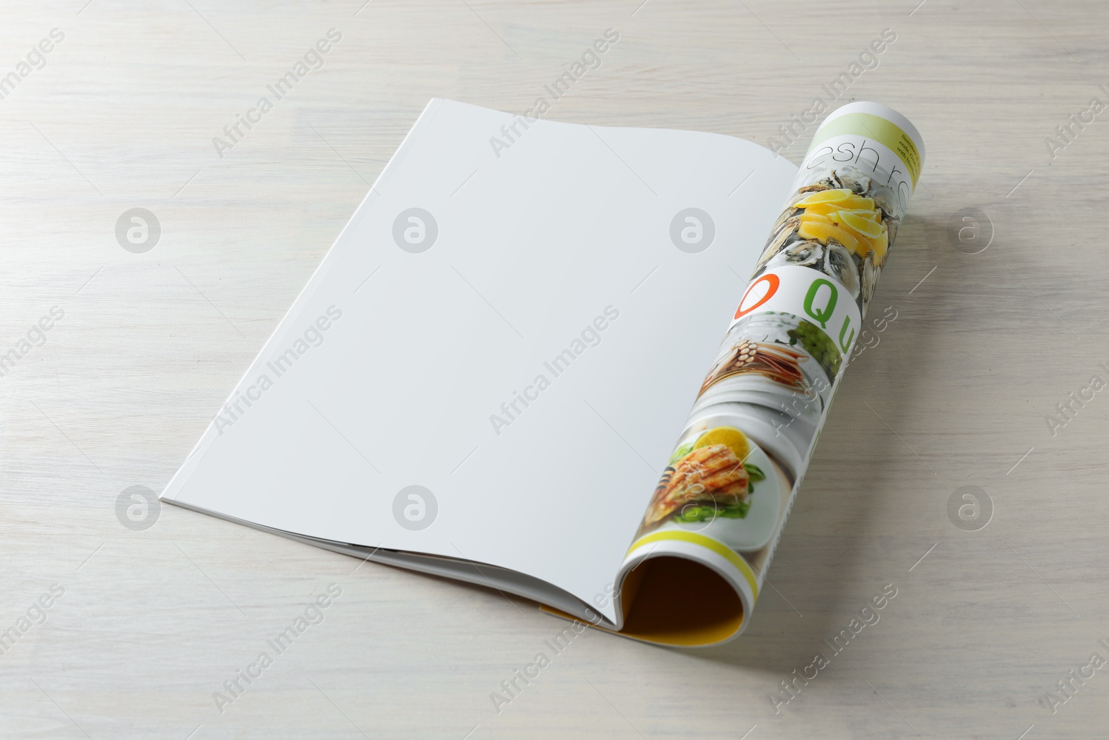 Photo of Open magazine on white wooden table. Mockup for design