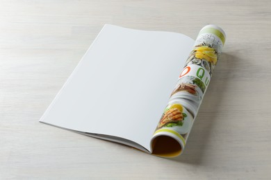 Photo of Open magazine on white wooden table. Mockup for design