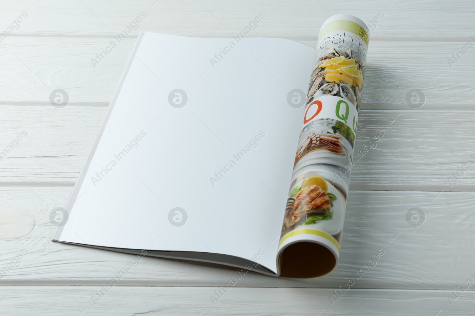 Photo of Open magazine with blank page on white wooden table. Mockup for design