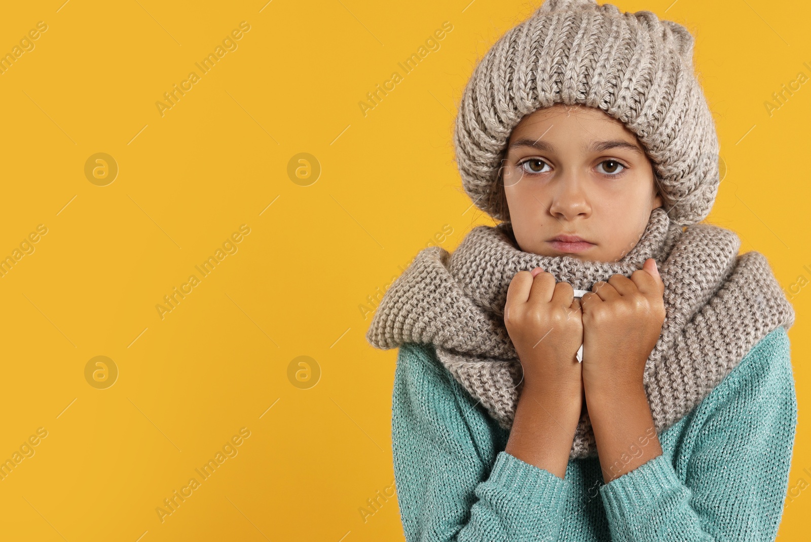 Photo of Cold symptom. Little girl suffering from fever on orange background, space for text