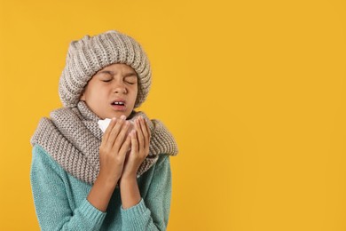 Cold symptom. Little girl with runny nose on orange background, space for text