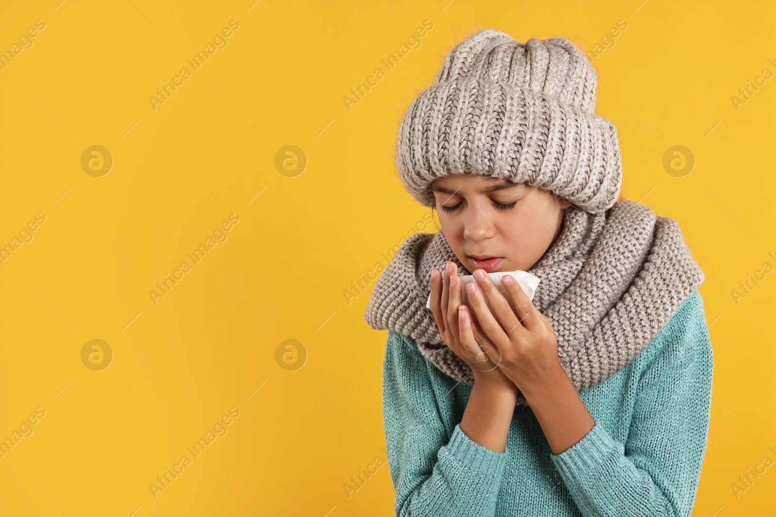 Photo of Cold symptom. Little girl with runny nose on orange background, space for text