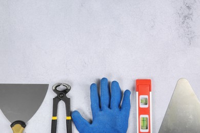 Many different construction tools on light textured table, flat lay. Space for text