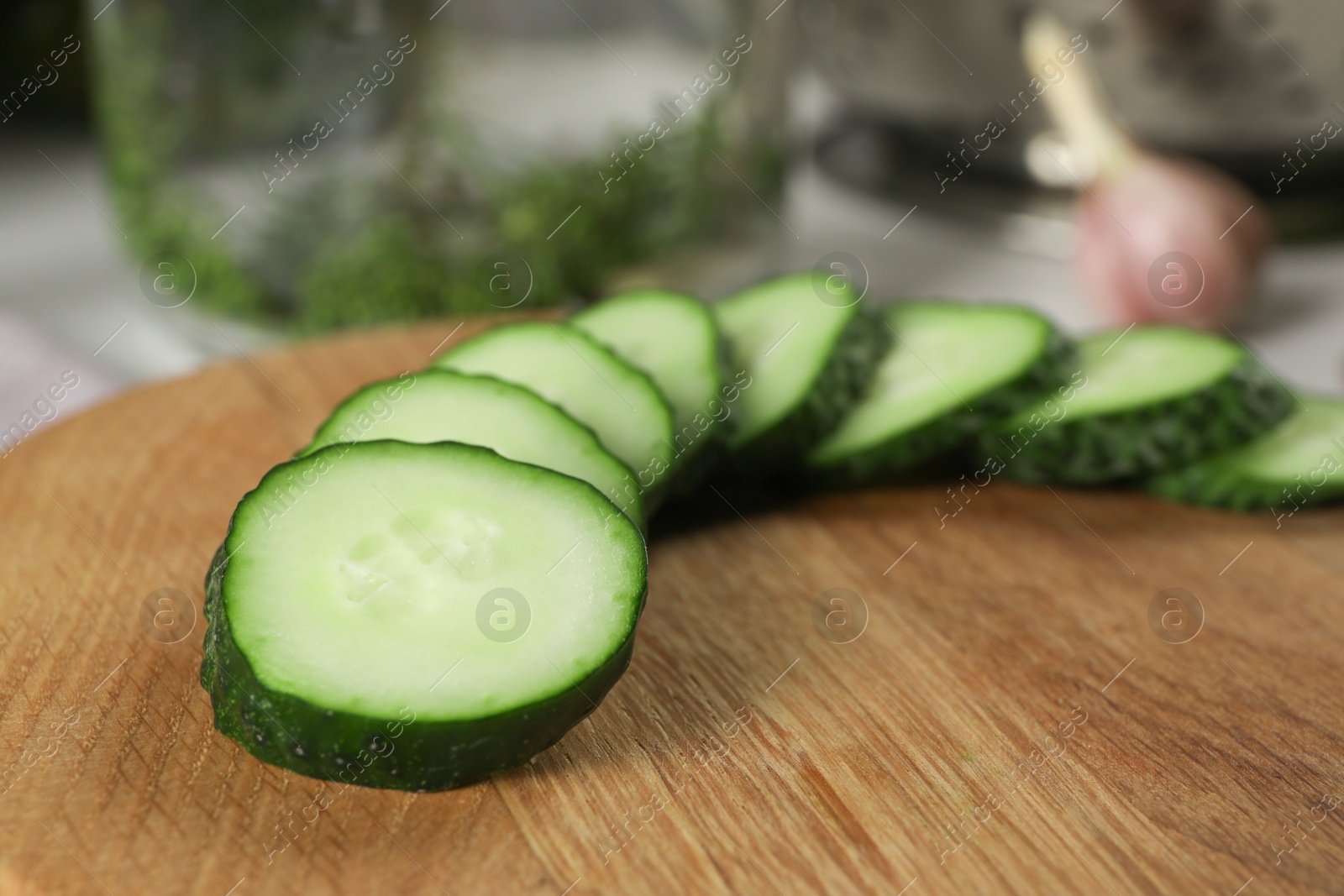 Photo of Board with fresh cut cucumber on table, closeup