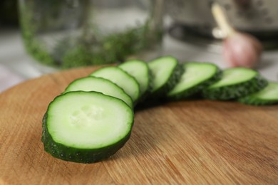 Photo of Board with fresh cut cucumber on table, closeup