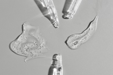 Photo of Cosmetic serum and pipettes on grey background, flat lay