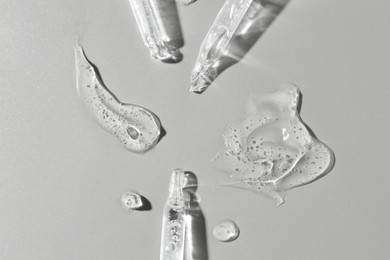 Photo of Cosmetic serum and pipettes on grey background, flat lay