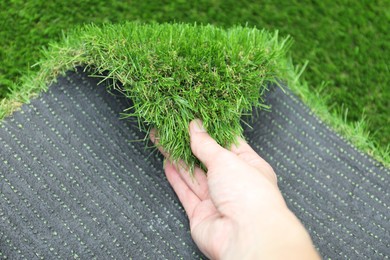 Woman with sheet of artificial turf, closeup