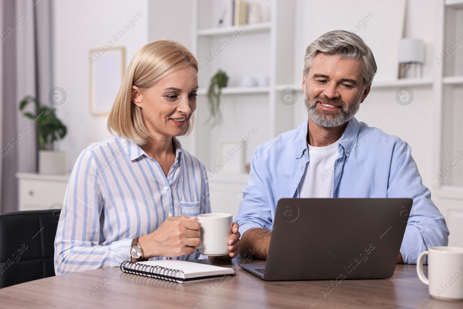 Photo of Pension savings. Couple planning budget at table indoors