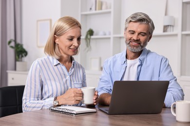 Pension savings. Couple planning budget at table indoors