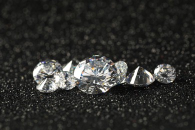 Photo of Beautiful dazzling diamonds on dark shiny background, closeup