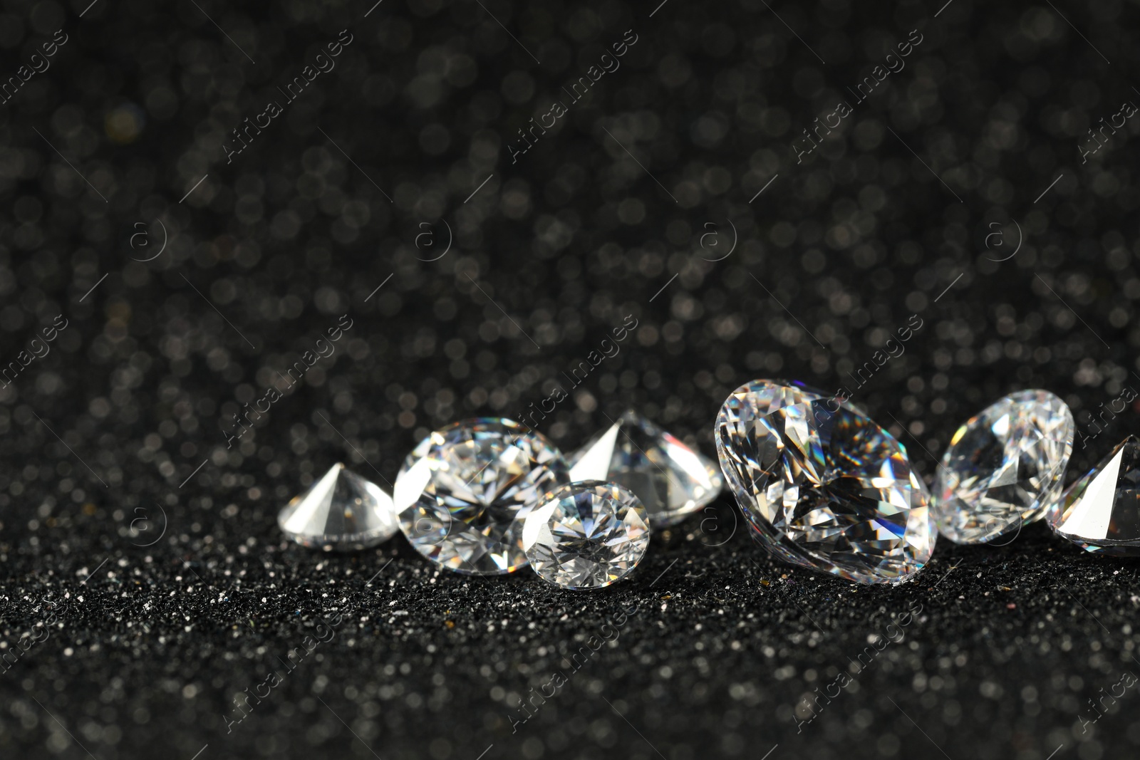 Photo of Beautiful dazzling diamonds on dark shiny background, closeup