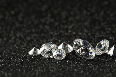 Photo of Beautiful dazzling diamonds on dark shiny background, closeup