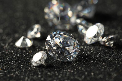 Photo of Beautiful dazzling diamonds on dark shiny background, closeup