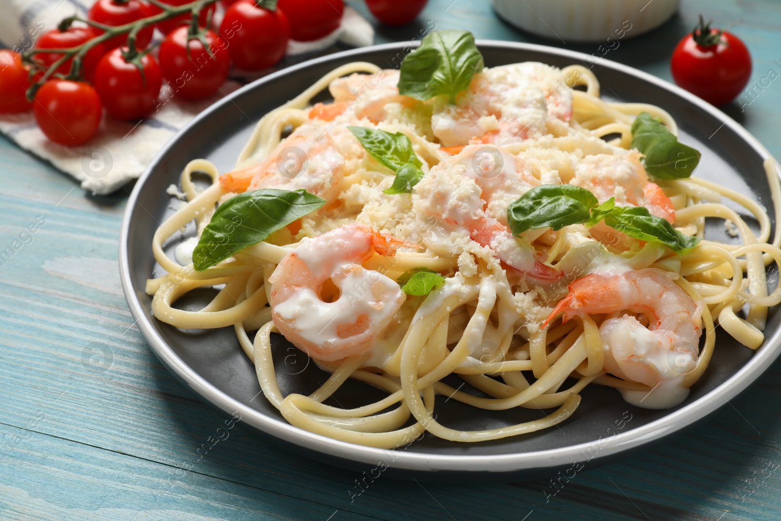 Photo of Tasty pasta with shrimps on light blue wooden table, closeup