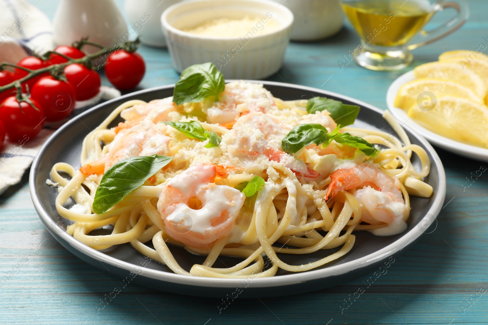 Photo of Tasty pasta with shrimps on light blue wooden table, closeup