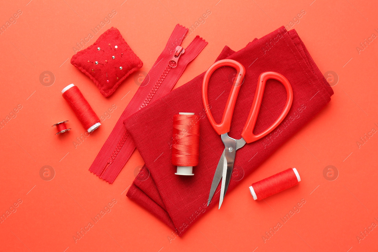 Photo of Flat lay composition with different sewing supplies on coral background