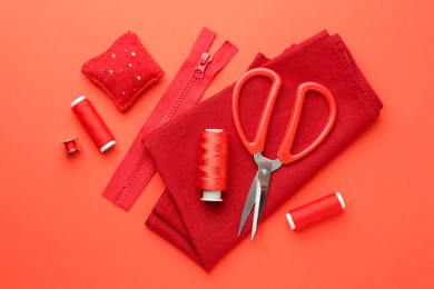 Photo of Flat lay composition with different sewing supplies on coral background