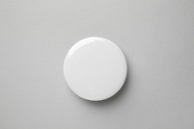 Photo of Blank white button badge on grey background, top view. Mockup for design