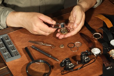 Man fixing mechanism of vintage wrist watch at table, closeup