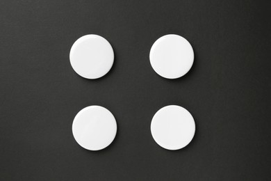 Photo of Blank white button badges on black background, top view. Mockup for design