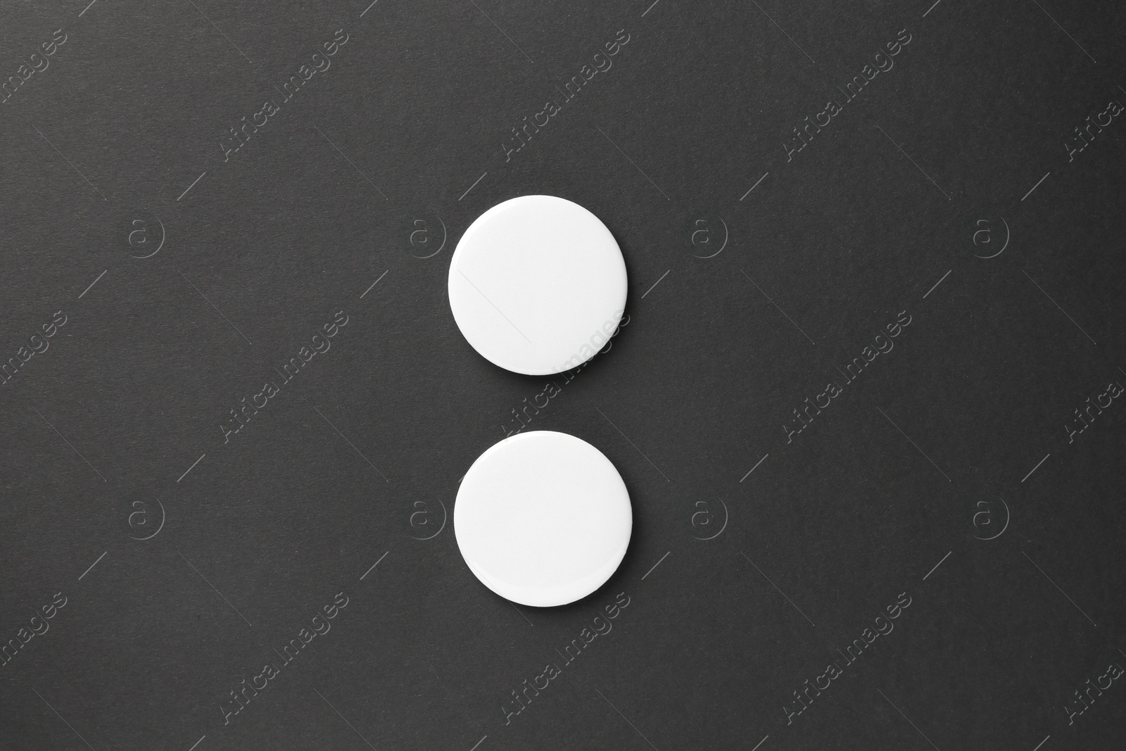 Photo of Blank white button badges on black background, top view. Mockup for design