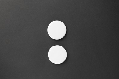 Photo of Blank white button badges on black background, top view. Mockup for design