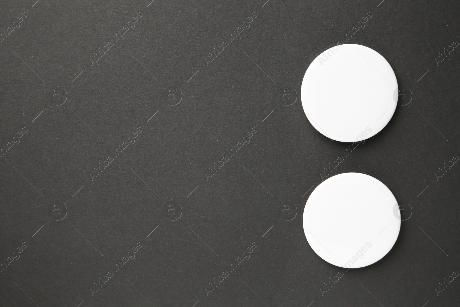 Photo of Blank white button badges on black background, top view and space for text. Mockup for design