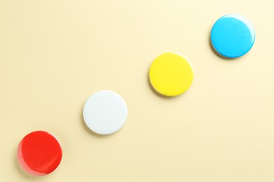 Photo of Colorful button badges on beige background, flat lay. Mockup for design