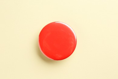 Photo of Red button badge on beige background, top view. Mockup for design