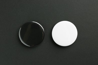 Button badges on black background, flat lay. Mockup for design