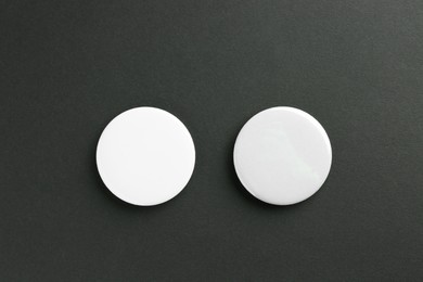 Button badges on black background, flat lay. Mockup for design