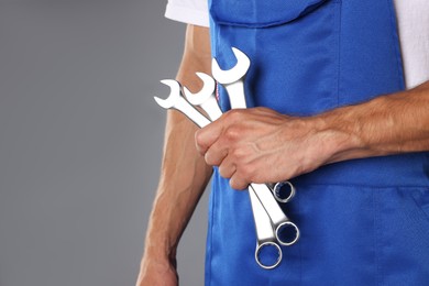 Photo of Auto mechanic with wrenches on grey background, closeup. Space for text