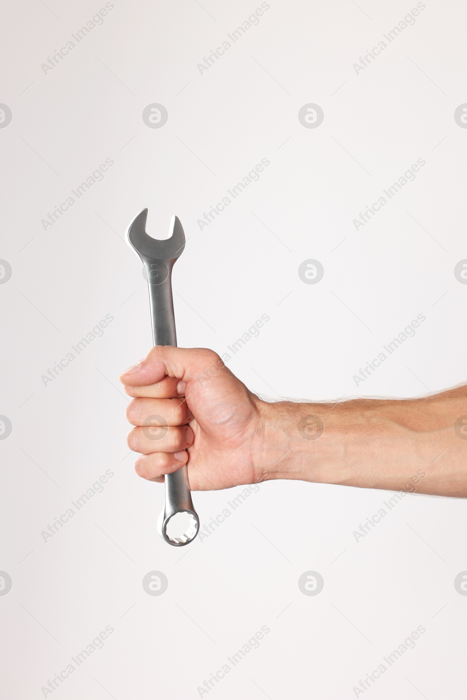 Photo of Auto mechanic with wrench on light grey background, closeup