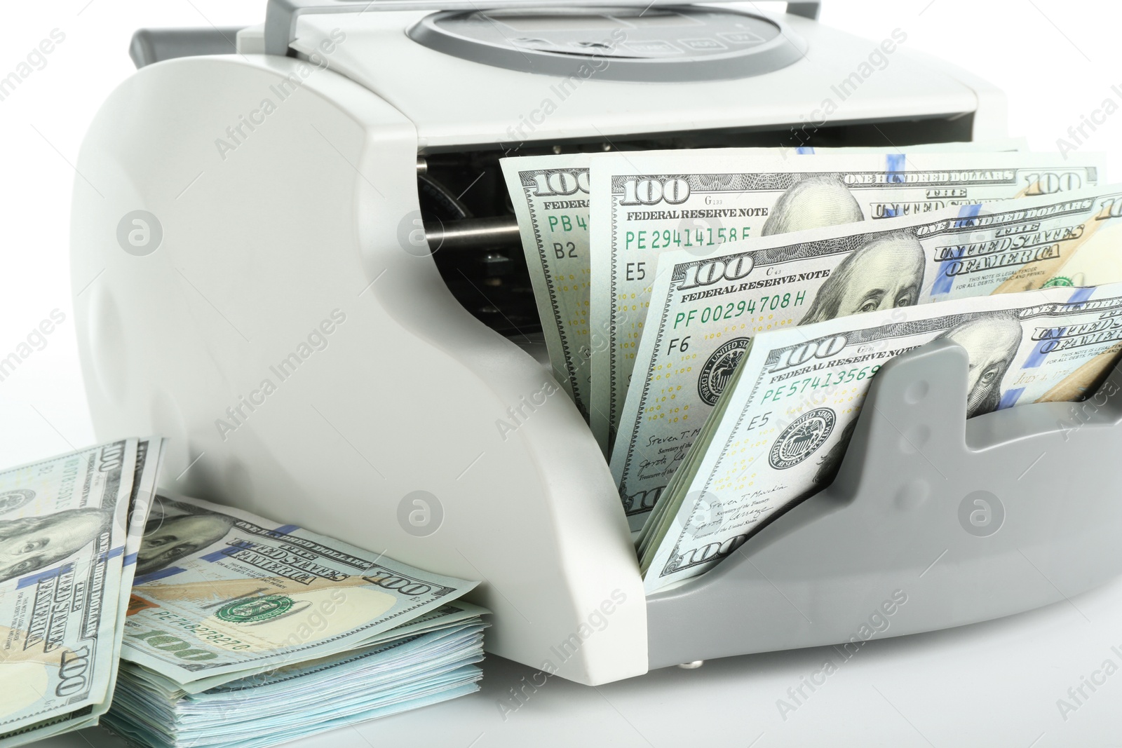 Photo of Money counter machine and dollar banknotes on white background, closeup