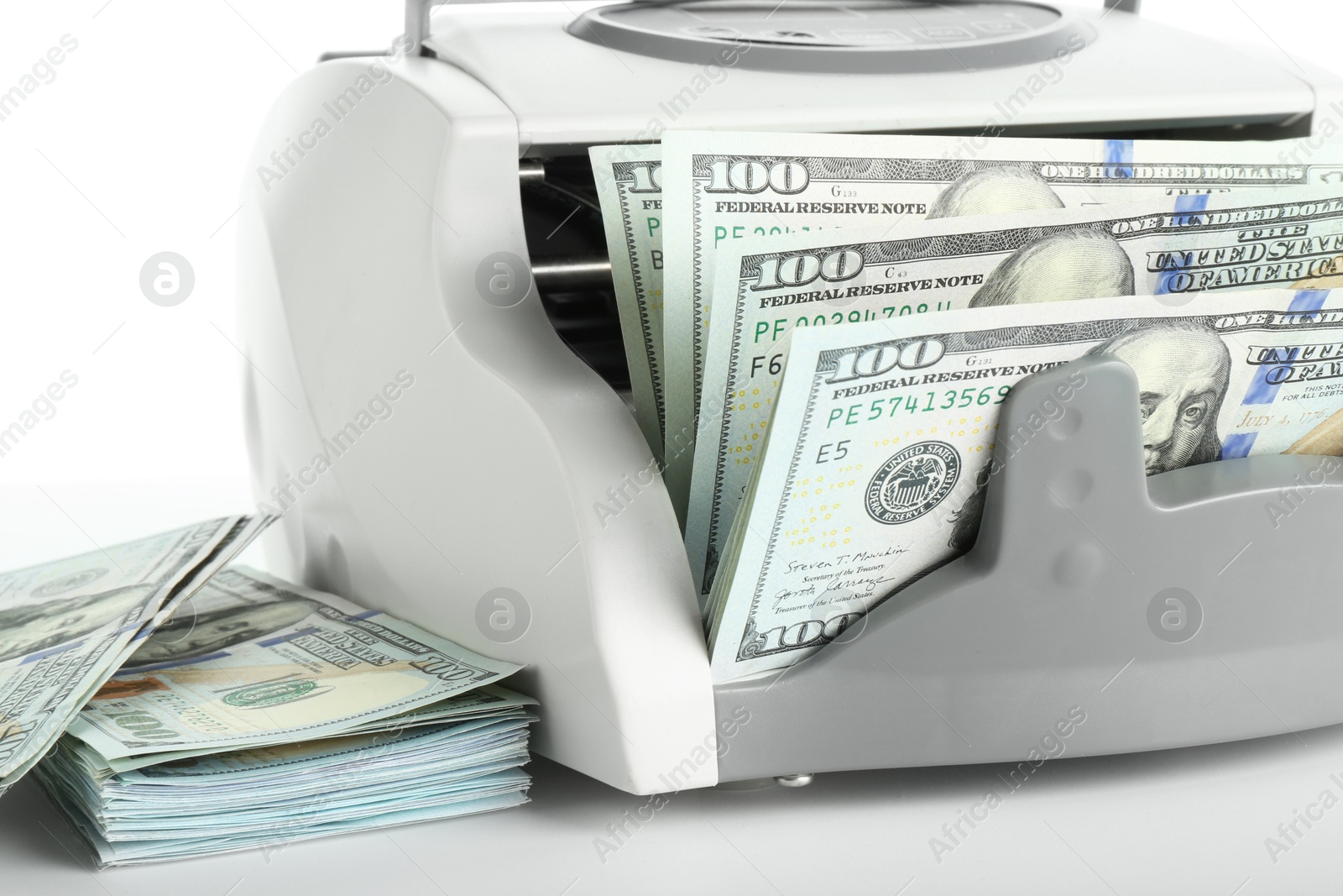 Photo of Money counter machine and dollar banknotes on white background, closeup