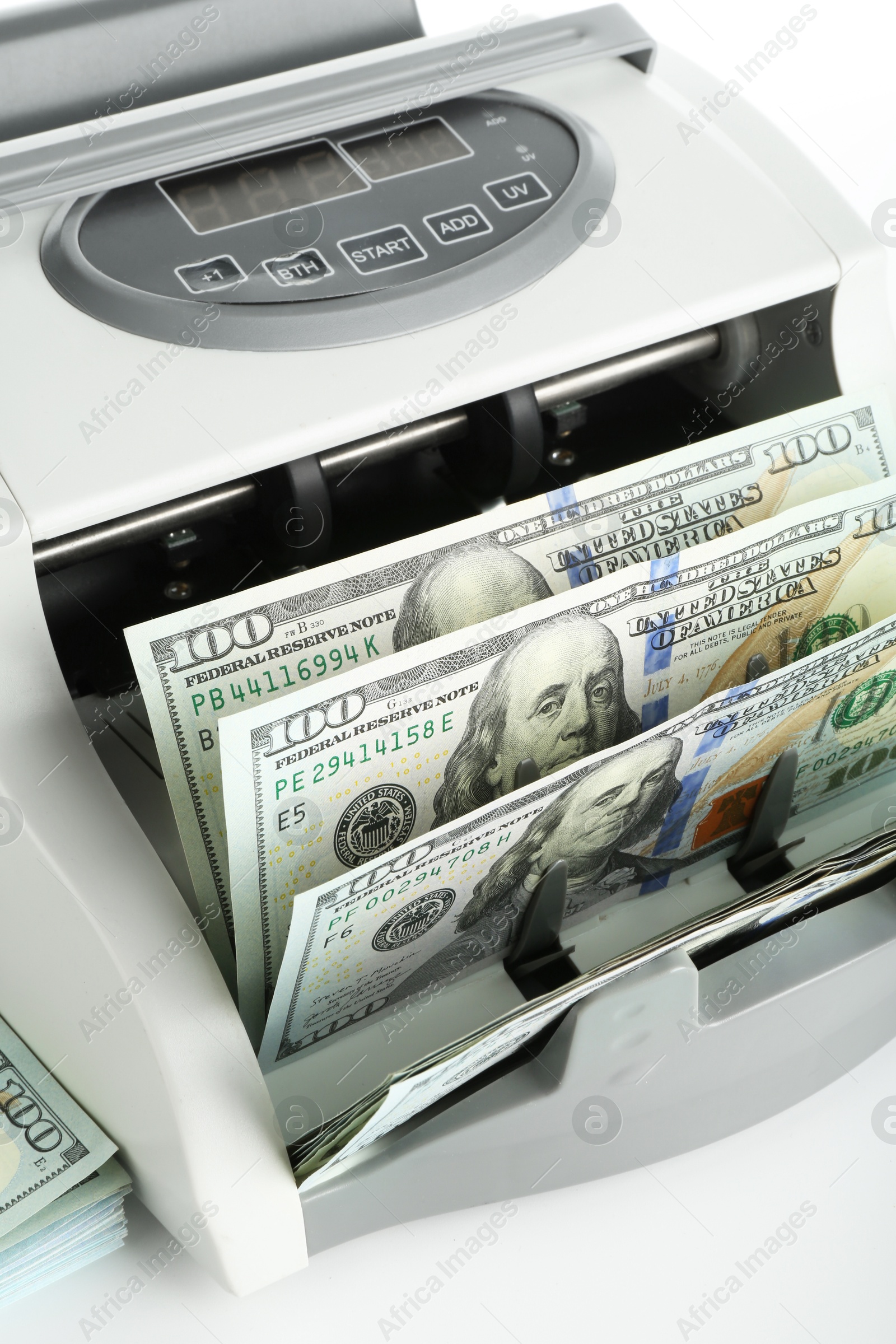 Photo of Money counter machine and dollar banknotes on white background, above view