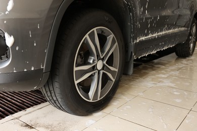 Auto covered with cleaning foam at car wash, closeup