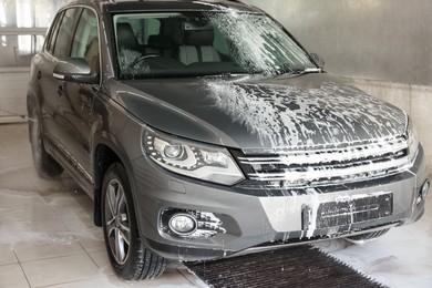 Auto covered with cleaning foam at car wash