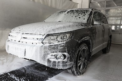 Auto covered with cleaning foam at car wash