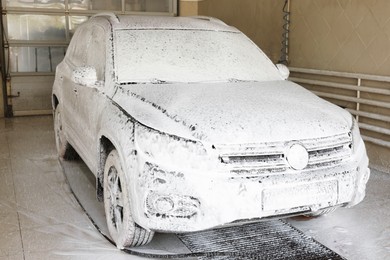 Photo of Auto covered with cleaning foam at car wash