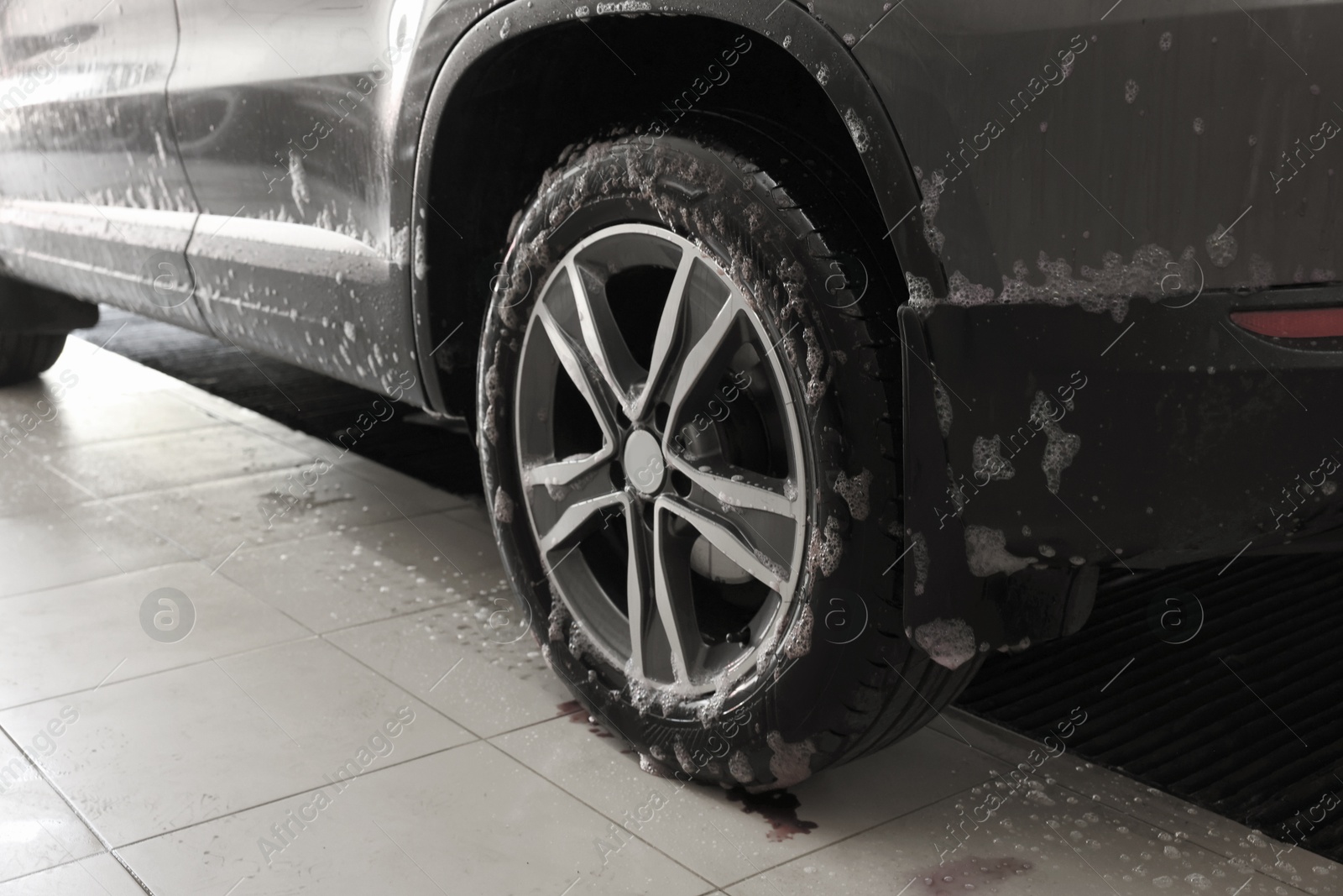 Photo of Auto covered with cleaning foam at car wash, closeup