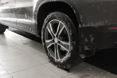 Auto covered with cleaning foam at car wash, closeup