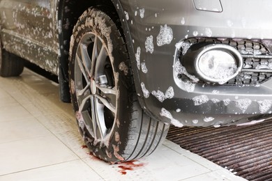 Auto covered with cleaning foam at car wash, closeup