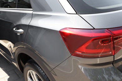 Photo of Modern grey car parked outdoors, closeup view