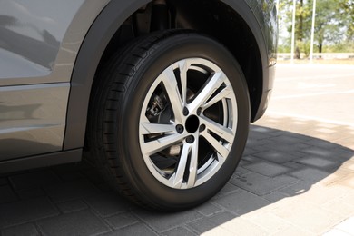 Photo of Modern car with big wheel outdoors, closeup