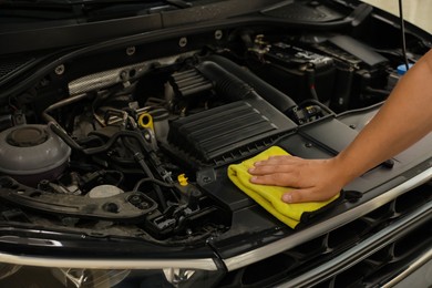 Man wiping auto engine with rag at car wash, closeup