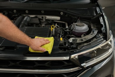 Man wiping auto engine with rag at car wash, closeup